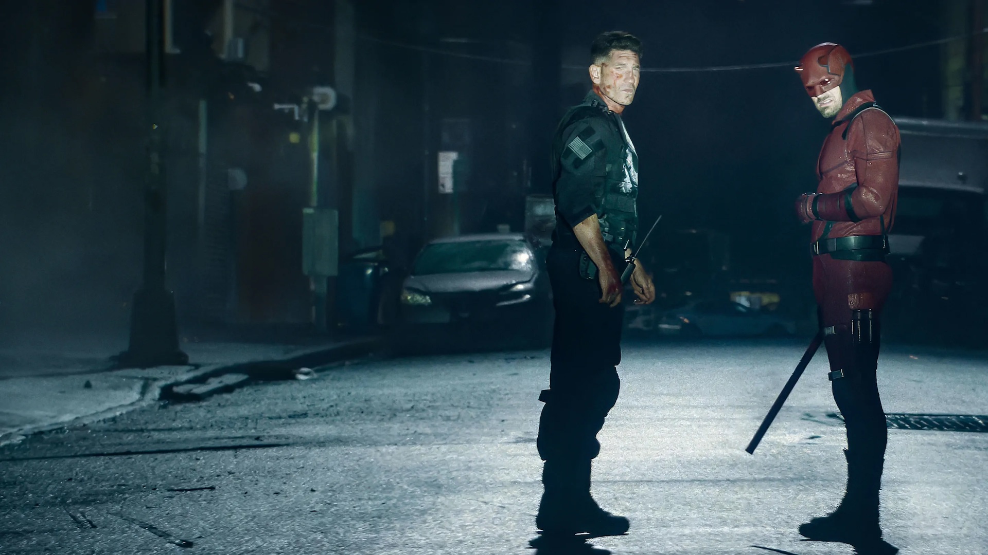 Punisher (Jon Bernthal) and Daredevil (Charlie Cox) stand on the street at nighttime, looking battered, in a still from Daredevil: Born Again