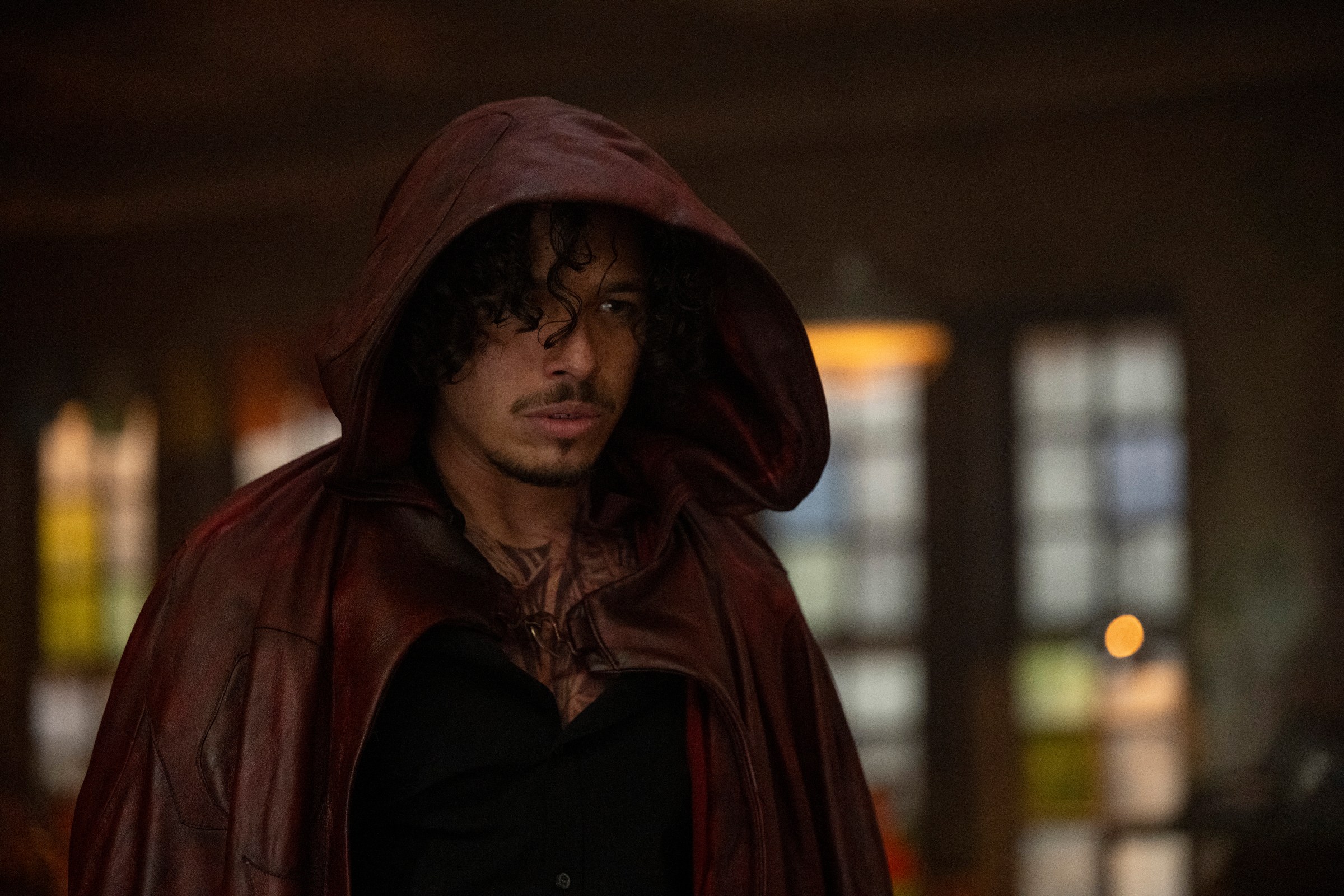 Anthony Ramos as Parker Robbins, standing in a red hood from Marvel’s Ironheart series